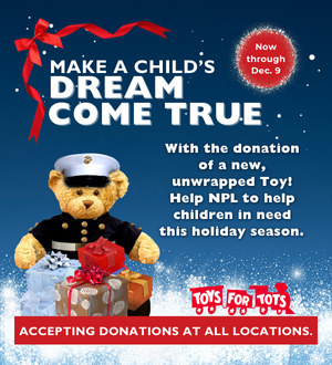 Stuffed bear in a Marine uniform behind wrapped gifts