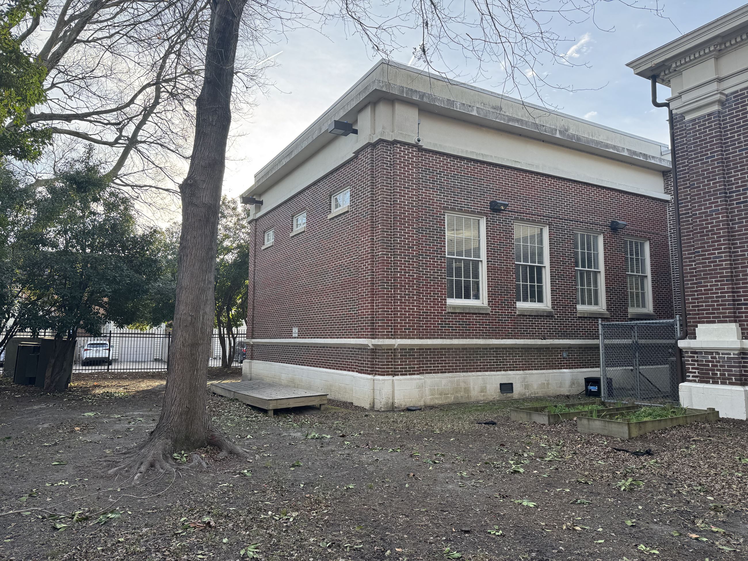 Picture of a yard with mostly dirt instead of grass with a small raised platform made of wood.